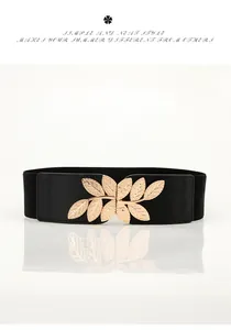 Detail of leaf-shaped gold alloy buckle on a black elastic waist belt for dresses