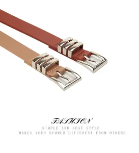 Detail of slim leather belts in tan and beige colors with silver square buckles and rings