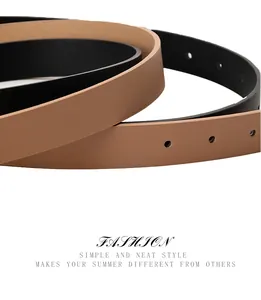 Close-up of slim black and khaki belts with polished texture and adjustable holes