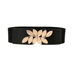 Elegant women's elastic belt with a golden leaf metal buckle on black stretchy fabric