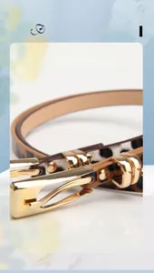 Vue rapprochée de la fine ceinture léopard avec boucle en métal doré sur marbre