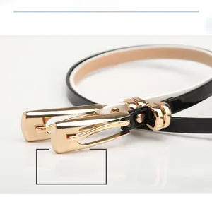 Détail de ceintures fines en cuir avec boucles rectangulaires en métal doré poli