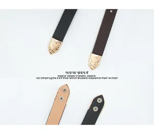 Detail of vintage embossed gold metal tips on black and brown slim leather belts