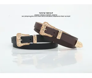 Detail of black and brown vintage leather belts with golden floral buckles and metal tips