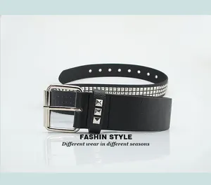 Détail de la ceinture punk noire avec doubles rangées de rivets pyramidaux argentés et boucle