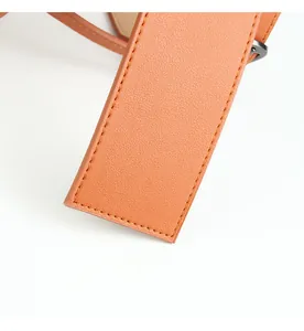 Macro view of bright orange leather waist belt showing fine texture and meticulous stitching