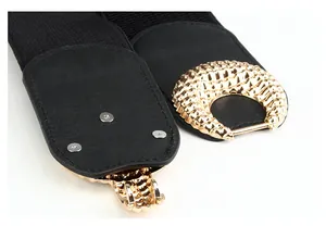 Detail of black elastic belt with textured gold semi-circle metal buckle and PU leather patch