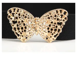 Detalle de hebilla de mariposa dorada calada sobre cinturón elástico negro para mujer