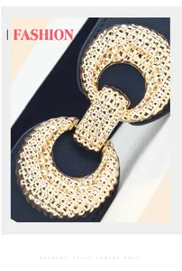 Detail of a navy blue elastic belt with a textured golden alloy buckle for women