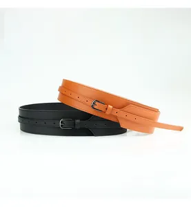 Detail of minimalist wide waist belts in black and camel leather with metal pin buckles