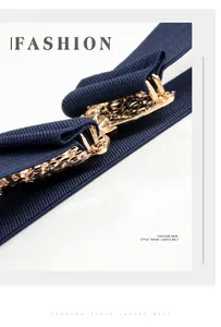 Primer plano de hebilla vintage dorada con motivo floral en cinturón elástico azul marino