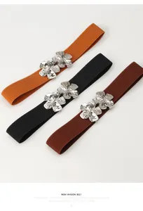 Trois ceintures élastiques jaunes, noires et marron avec boucles fleurs argentées