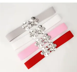 Détail de quatre ceintures élastiques pour femmes avec boucles de fleurs en métal argenté