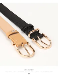 Détail de ceintures en cuir noir et camel avec boucles dorées style bambou