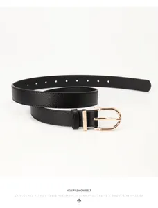 Détail de la ceinture noire en cuir grainé avec une boucle dorée en forme de D