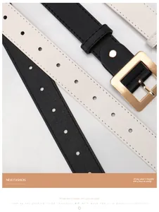 Dettaglio di cinture in pelle nera e bianco crema con fibbie quadrate dorate lucide