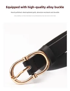 Close-up of golden oval alloy buckle with polished finish on black litchi leather belt