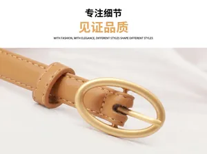 Detailaufnahme von braunem Ledergürtel mit goldener ovaler Schnalle und feinen Nähten