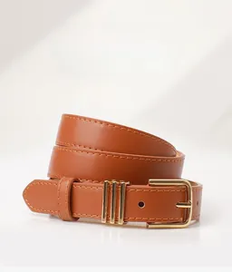 Détail d'une ceinture en cuir marron avec boucle en alliage dorée et coutures propres