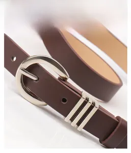 Macro detail of dark brown leather belt featuring a polished silver D-ring buckle and triple loops