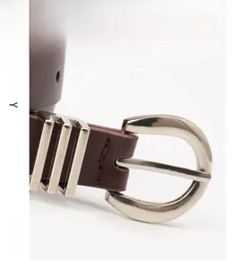 Detail of premium alloy D-buckle and textured brown leather belt stitching