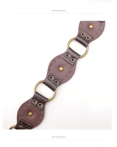 Detail of bohemian brown leather belt with vintage gold studs and metal ring links
