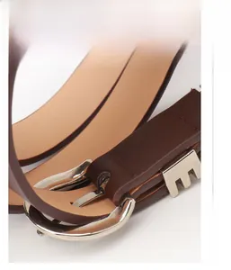Detail view of the silver alloy buckle back and stitching on a brown leather belt