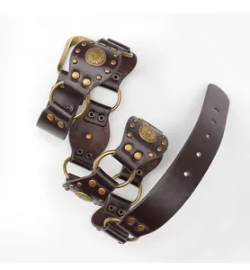 Detail of vintage Western leather belt with bronze rings and sunflower embossed metal studs