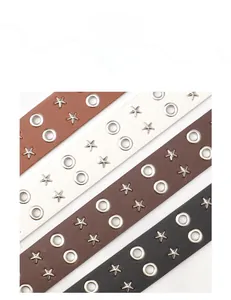 Flat lay of four punk style leather belts with silver grommets and star rivets in four colors