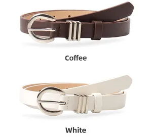 Close-up of minimalist slim belts in coffee and white with silver oval buckles
