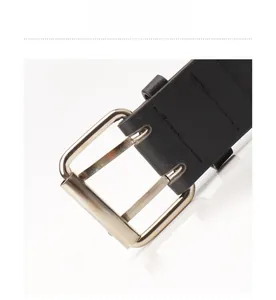 Detail of a punk style double prong gold plated metal buckle on a black leather belt