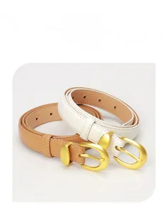 Detail of white and brown slim leather belts with gold round buckles on studio background