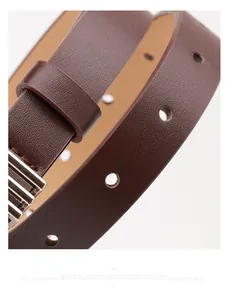 Detail shot of brown lychee texture leather belt with silver metal pin buckle