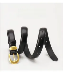 Close-up of minimalist black leather belt for women with elegant gold oval buckle detail