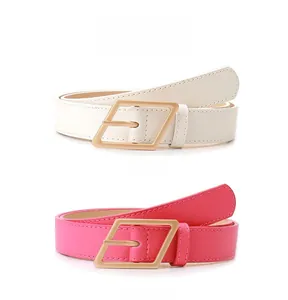 Dettaglio di cinture sottili bianche e rosso rosa con fibbie geometriche in oro opaco