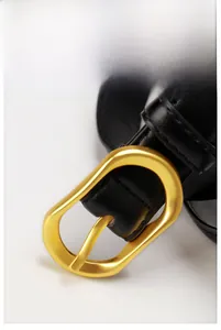 Vue détaillée de la boucle en alliage doré mat et ceinture en cuir noir avec coutures fines