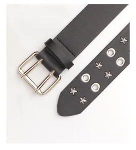 Macro detail of black leather punk belt with silver star studs and double grommets
