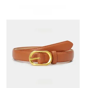 Détail d'une ceinture en cuir camel avec une boucle ovale élégante en or mat pour femmes