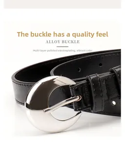 Detailed macro view of black leather belt featuring a polished silver crescent alloy buckle