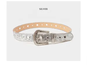 Detalle de cinturón plateado de lentejuelas con hebilla y punta decorada con strass