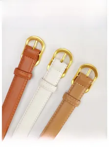 Gros plan de ceintures fines en cuir marron et blanc avec boucles dorées brillantes