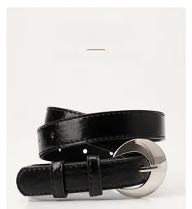 Detail of glossy black leather belt with silver moon crescent buckle for fashion accessories