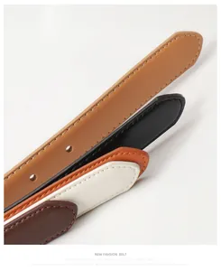 Detail of multi-color slim leather belts featuring precise stitching and metal eyelets