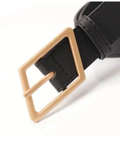Dettaglio di cintura in pelle nera con fibbia ad ardiglione geometrica triangolare oro