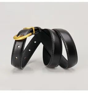 Detail of slim black leather belt with golden U-shaped buckle and fine stitching