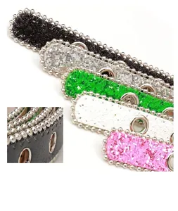 Détail de ceintures à paillettes en cinq couleurs avec perles en métal et œillets