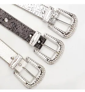 Detalle de cinturones brillantes estilo Y2K con pedrería en hebillas y correas