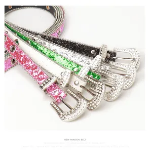 Gros plan des boucles en strass Y2K sur des ceintures pailletées en rose, vert et noir