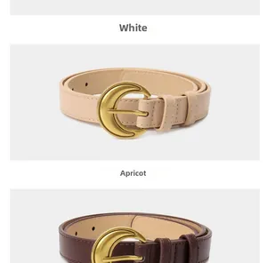 Detail of crescent moon metal buckle on white and apricot vintage style belts