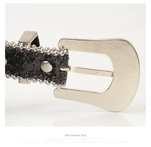Détail de la boucle ardillon argentée avec ceinture à paillettes noires et perles